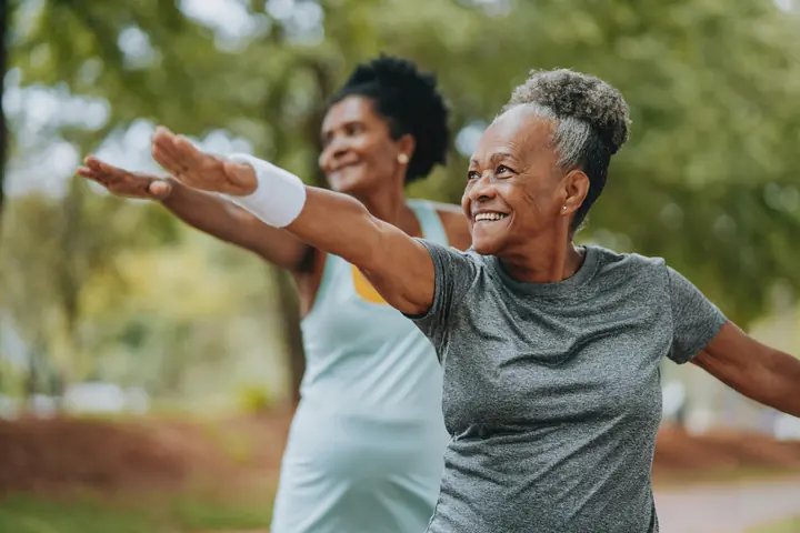 Two women of different ages stretching outdoors