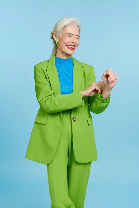 A smiling woman in a bright green suit